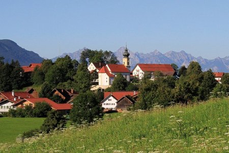 Blick auf Wildsteig mit den Alpen im Hintergrund